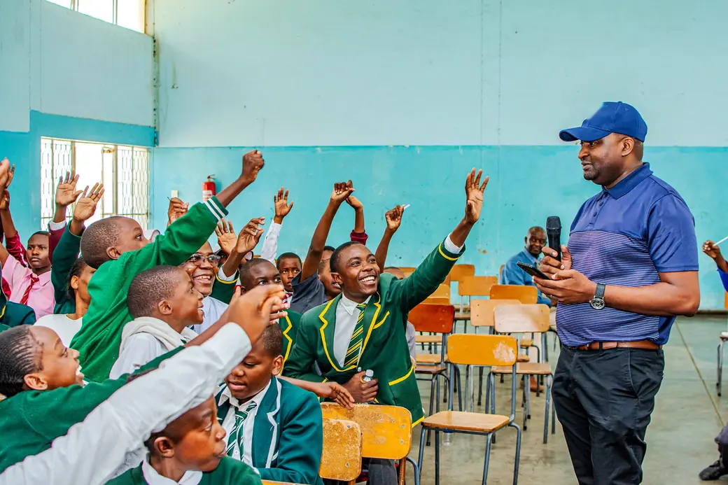 Learners raising their hands during a schools financial literacy session